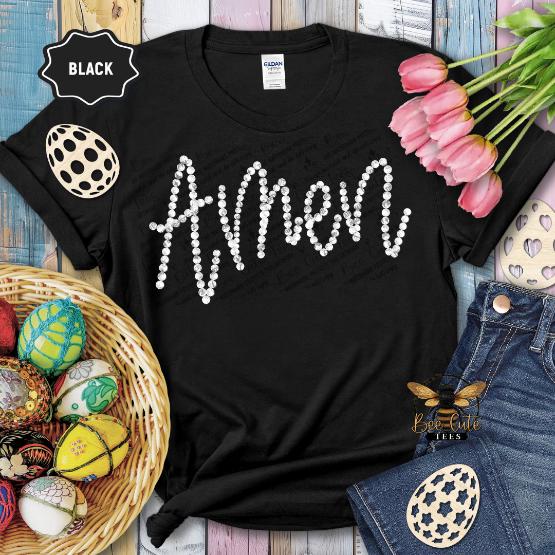 Black t-shirt with 'Amen' text, surrounded by Easter decorations on a wooden surface.