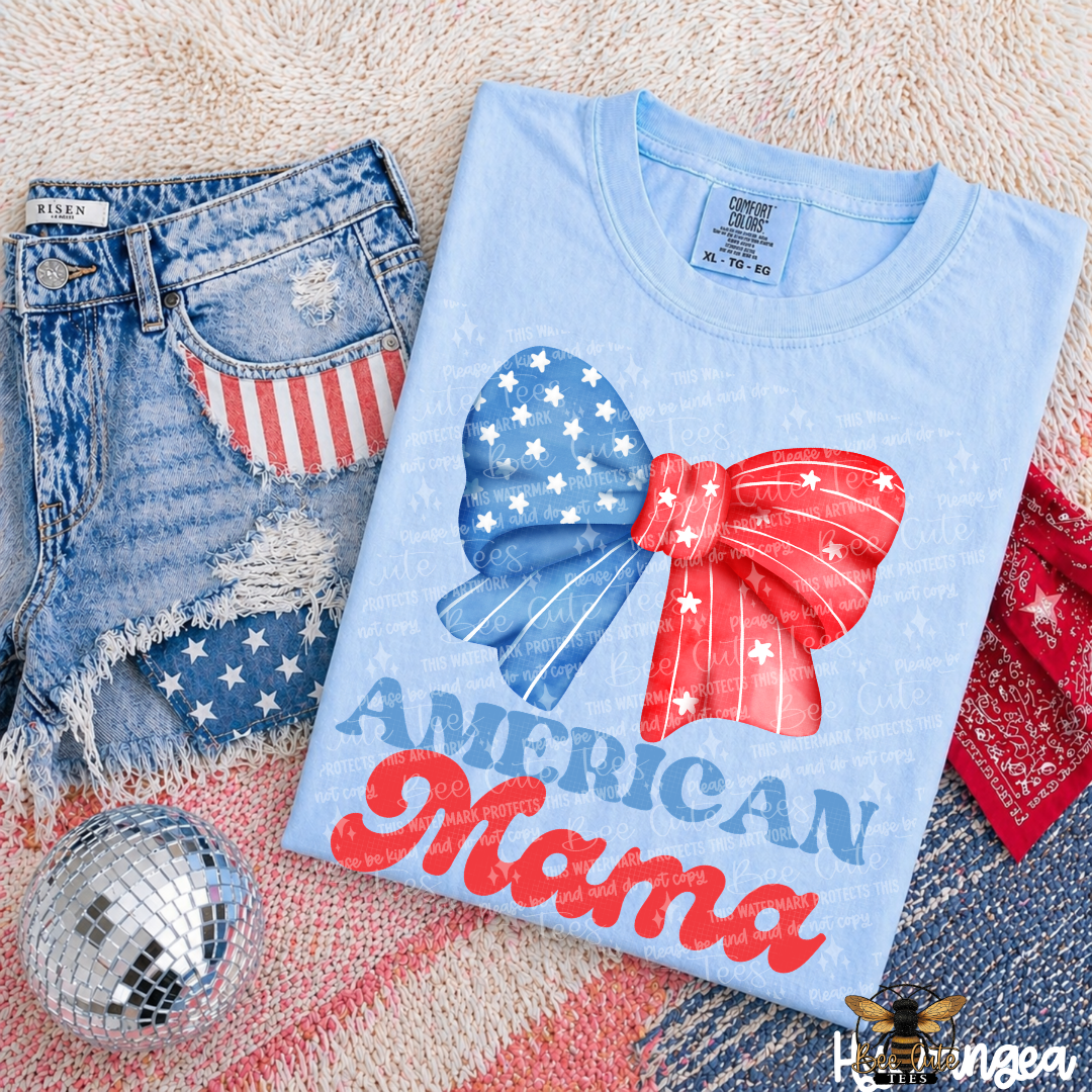 Light blue t-shirt with 'American Mama' design, denim shorts with American flag, and disco ball on a textured surface.