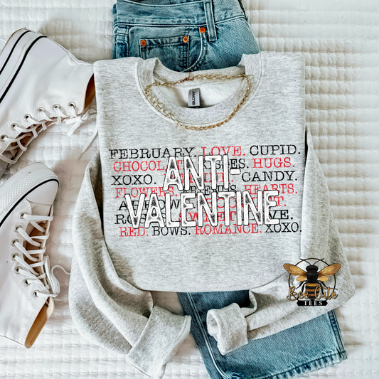 Gray sweatshirt with Valentine's Day text design on a white surface with jeans and sneakers.