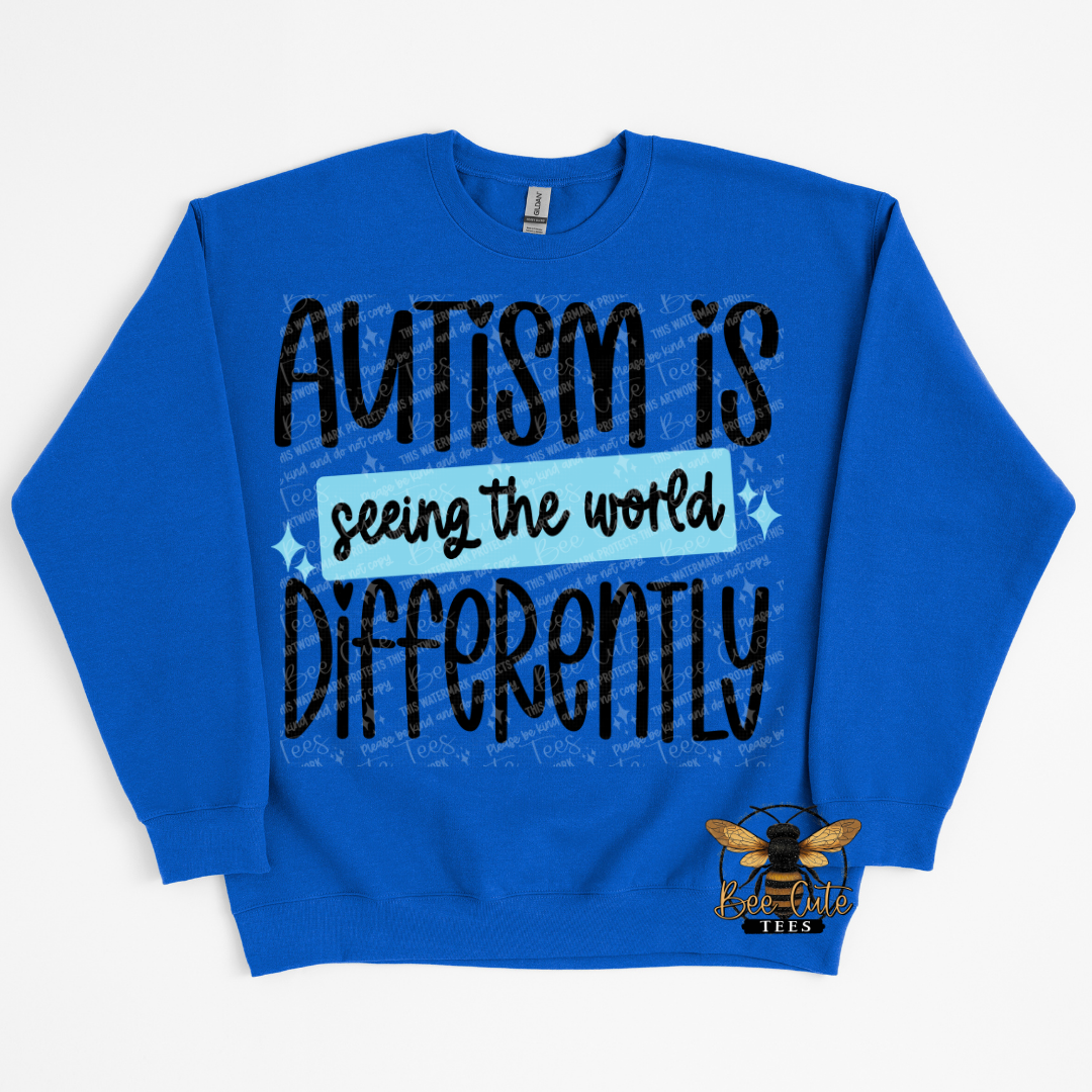 Blue sweatshirt with 'Autism is seeing the world differently' text on a white background