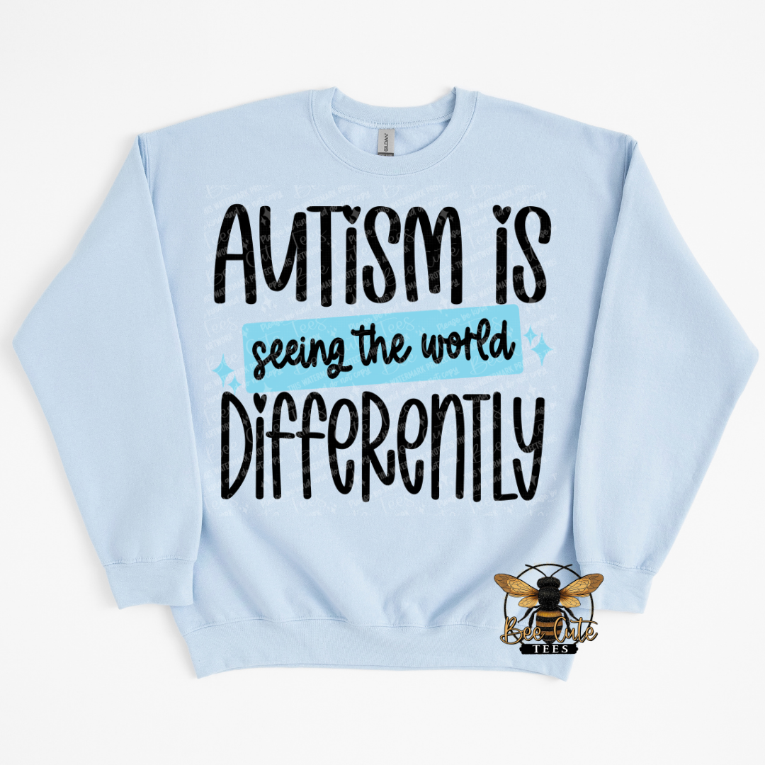 Light blue sweatshirt with 'Autism is seeing the world differently' text on a white background