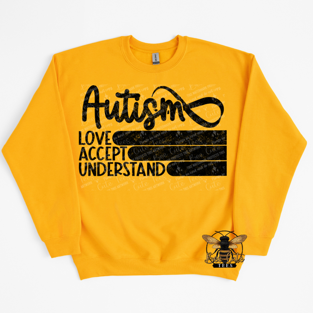 Yellow sweatshirt with black text 'Autism Love Accept Understand' on a white background