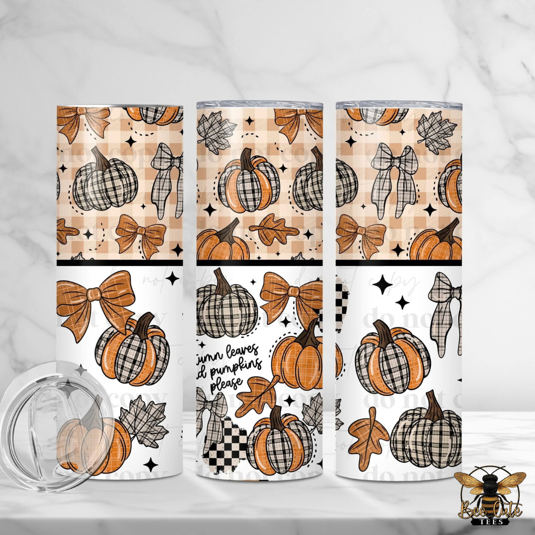 Three insulated tumblers with a fall harvest pattern of plaid pumpkins, bows, leaves, and stars, shown on a white marble background with a clear lid in the foreground.