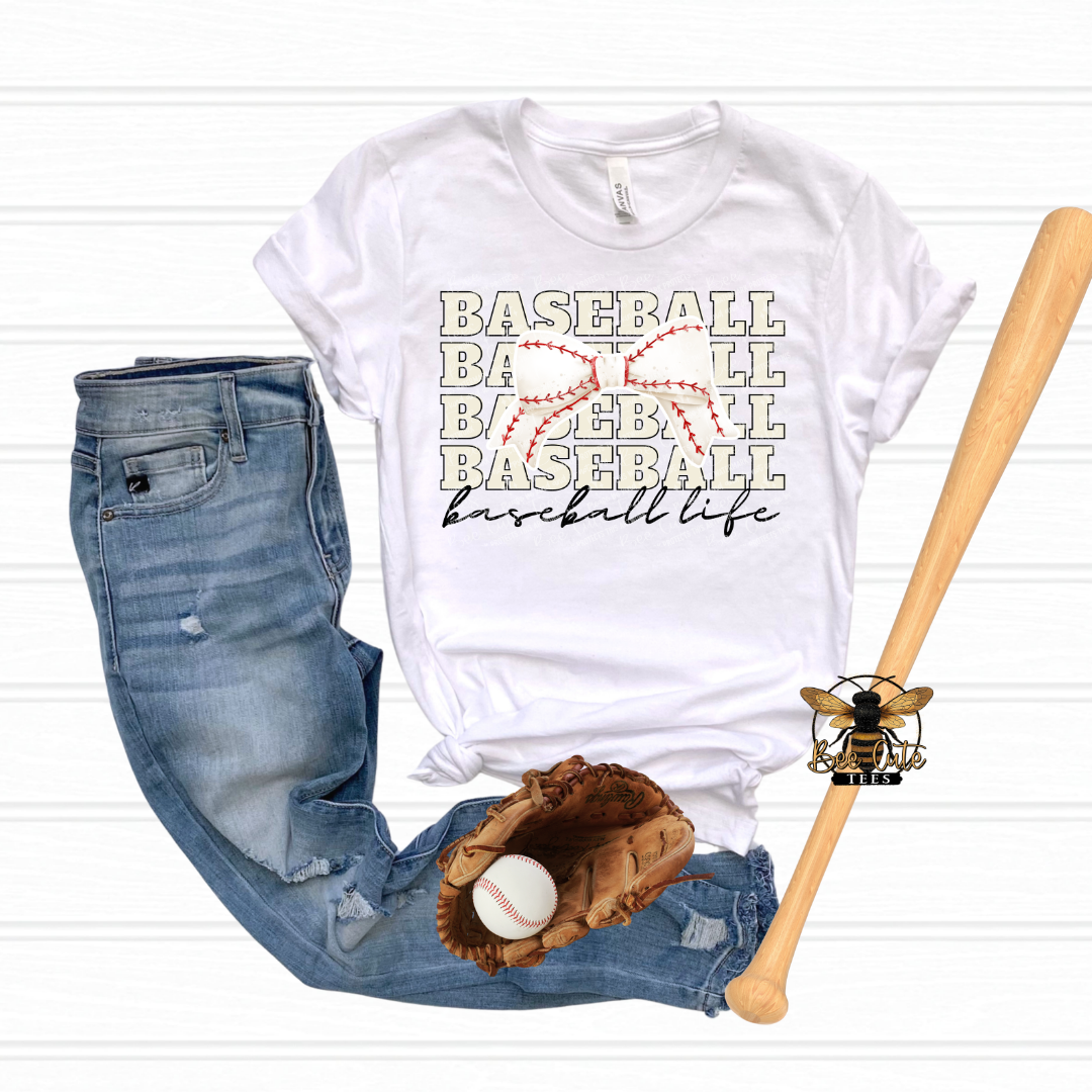 White t-shirt with 'Baseball Life' text, jeans, baseball glove, ball, and bat on a white background