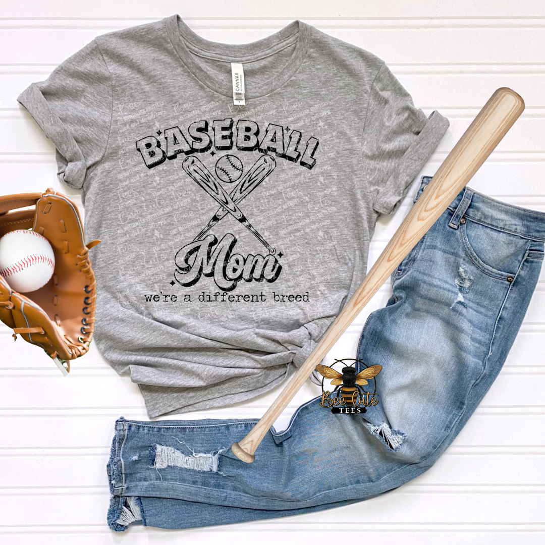 Gray t-shirt with 'Baseball Mom' text, baseball bat, baseball, and jeans on a white background