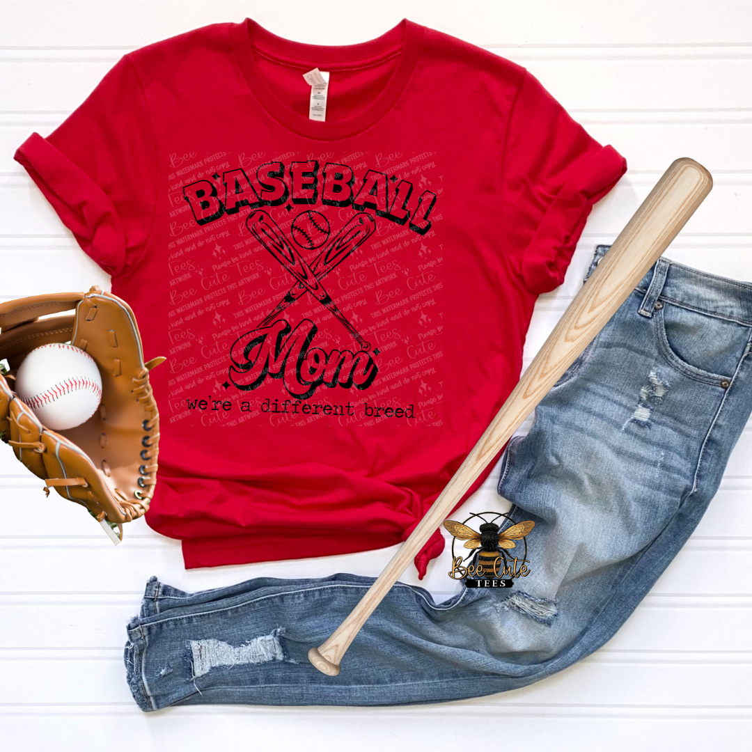 Red t-shirt with 'Baseball Mom we're a different bread' text, baseball bat, baseball, and jeans on a white background