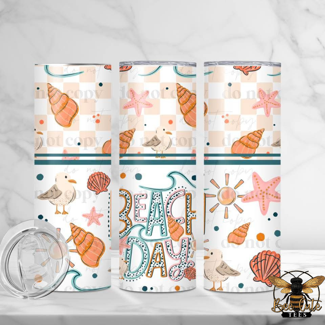 Three tumblers with beach-themed designs on a white background