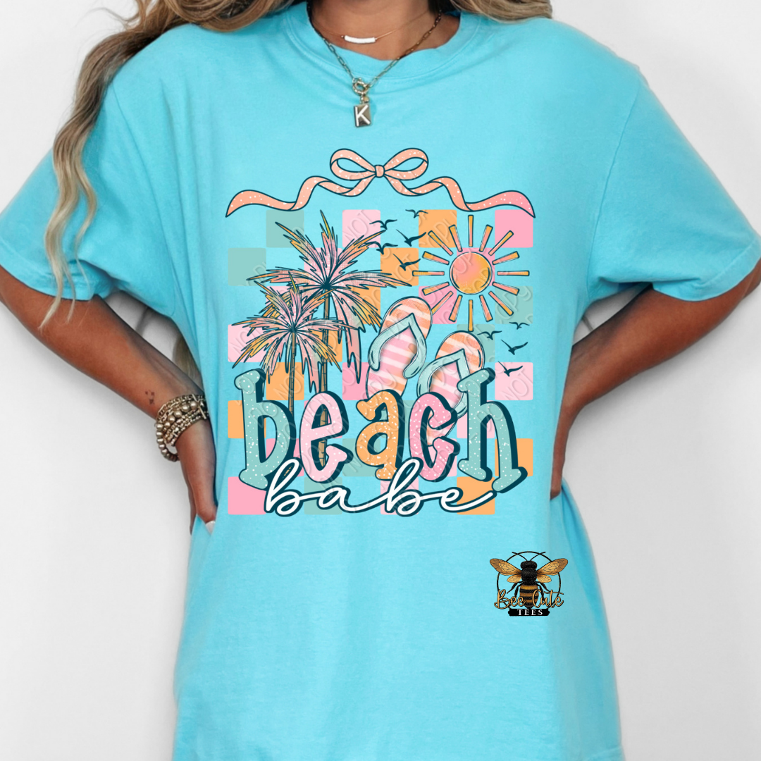 Person wearing a turquoise t-shirt with 'beach babe' design on a white background