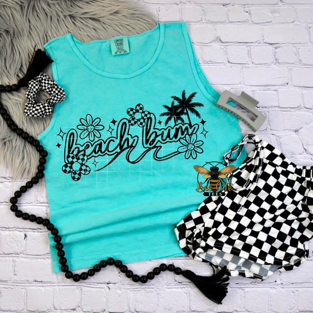 Turquoise tank top with 'Beach Bum' text and palm trees, surrounded by decorative items on a white brick background.