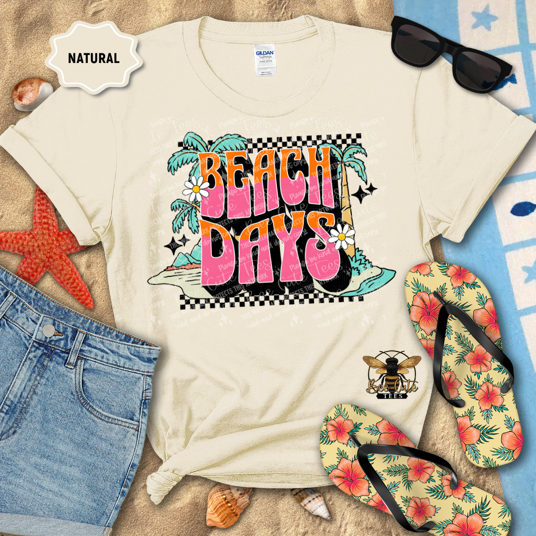 Beach-themed t-shirt with 'Beach Days' design, sunglasses, flip-flops, and beach accessories on a sandy background.