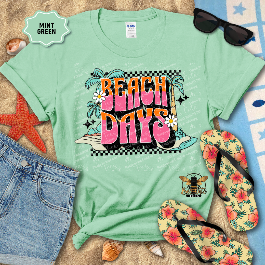 Mint green t-shirt with 'Beach Days' design on a beach-themed background with sunglasses, flip-flops, and starfish.