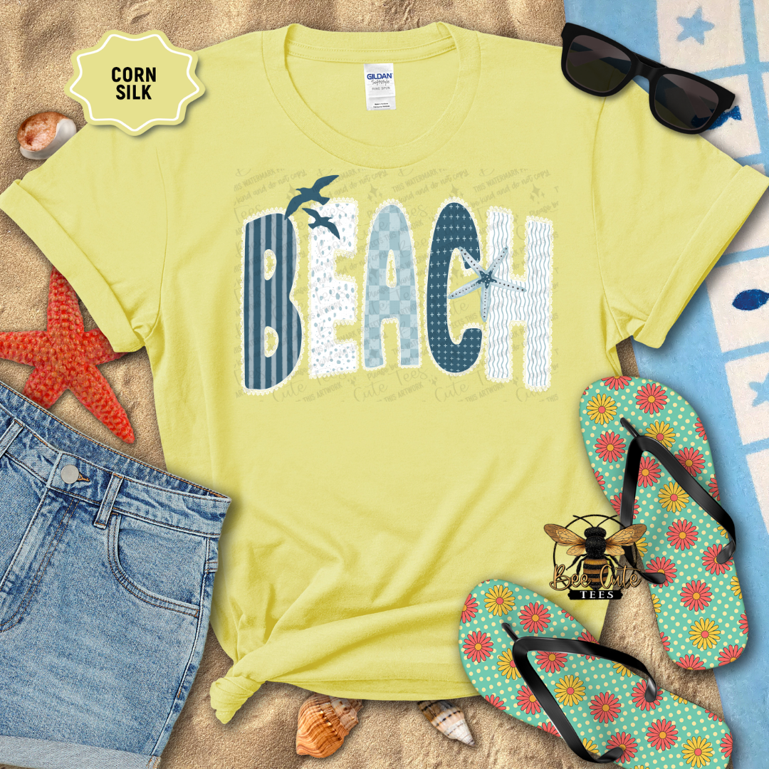 Yellow t-shirt with 'BEACH' print on a sandy background with flip-flops and sunglasses.