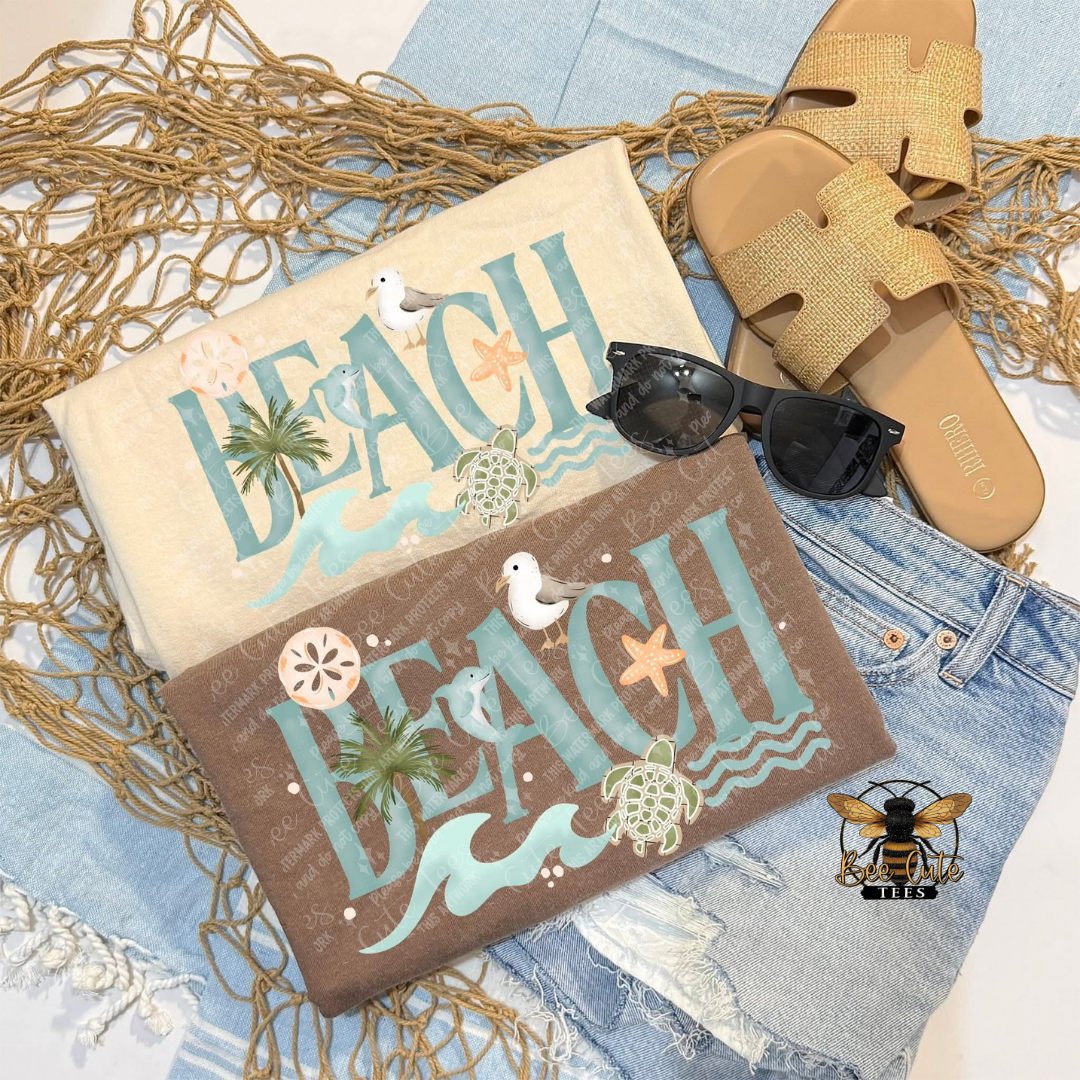 Two t-shirts with 'Beach' text, sunglasses, and sandals on a textured surface.
