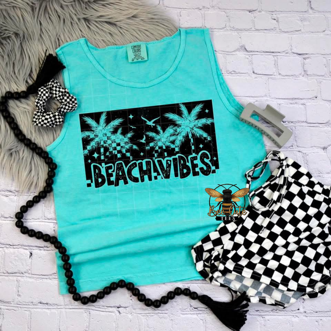 Turquoise tank top with 'Beach Vibes' print on a white brick background