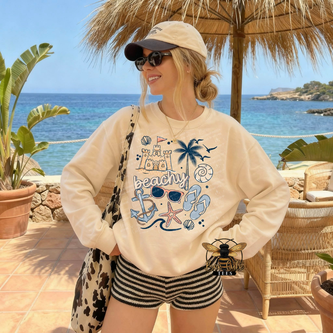Woman wearing a beach-themed sweatshirt by the ocean