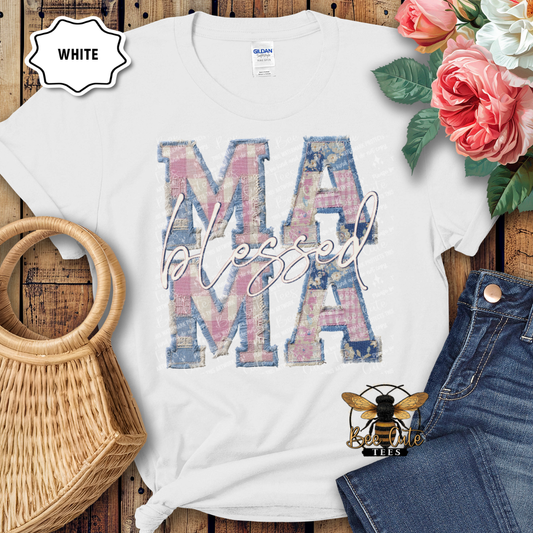 White t-shirt with 'Mama' graphic design on a wooden surface with flowers and denim jeans.
