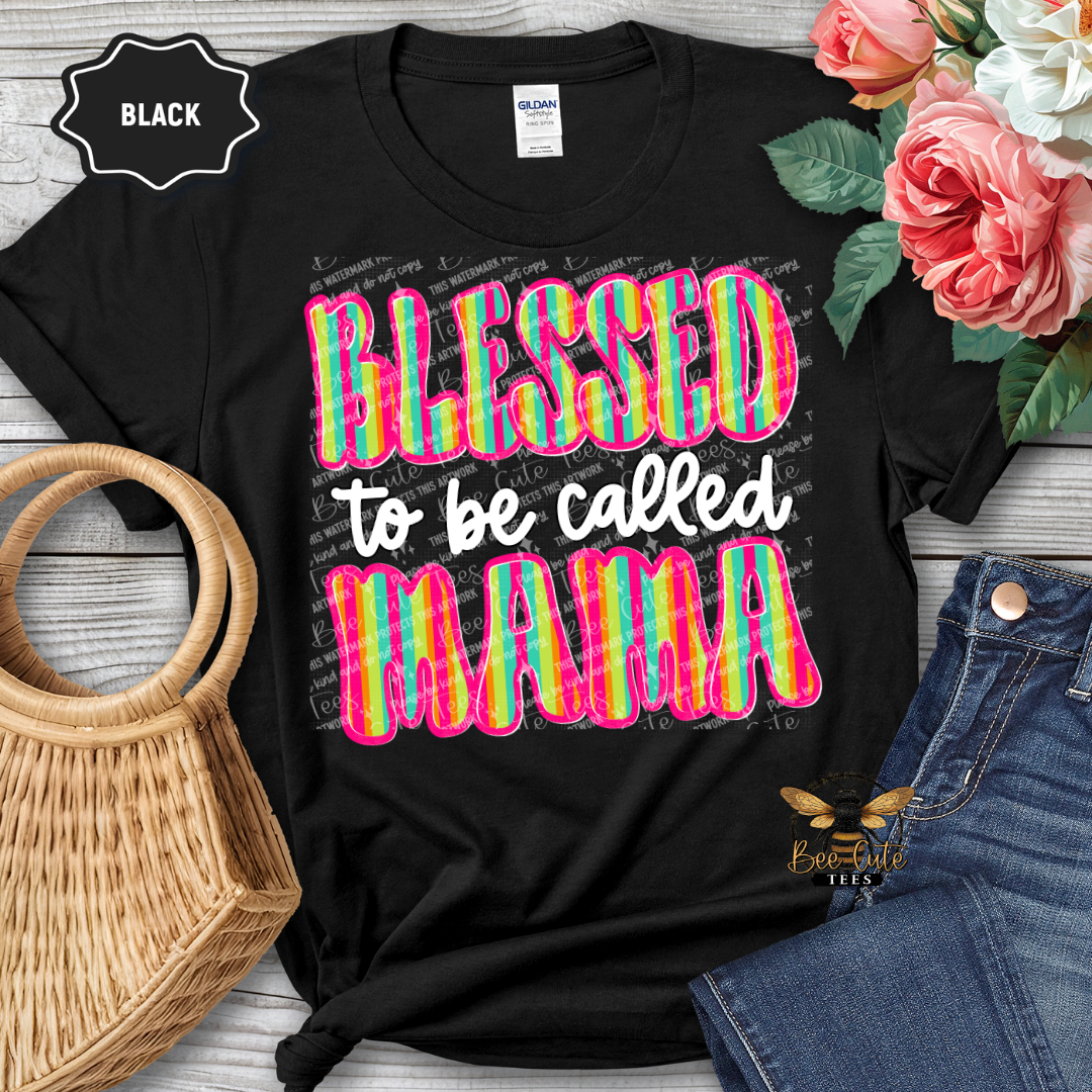 Black t-shirt with colorful 'Blessed to be called MAMA' text, displayed with flowers and jeans.