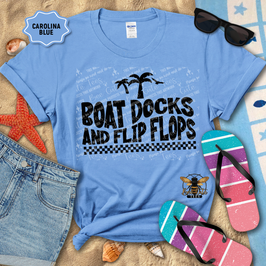 Blue t-shirt with 'Boat Docks and Flip Flops' text, sunglasses, and flip-flops on a sandy background.