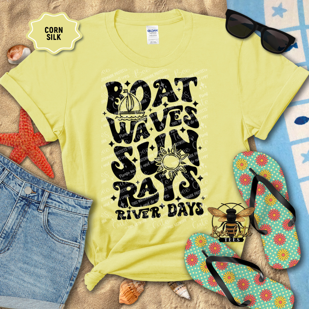 Yellow t-shirt with beach-themed design on a sandy surface with flip-flops and sunglasses.