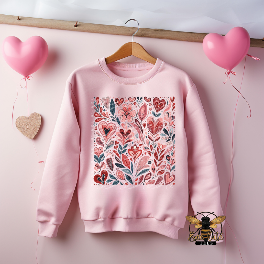 Pink sweatshirt with floral pattern on a wooden hanger against a pink background with heart balloons.