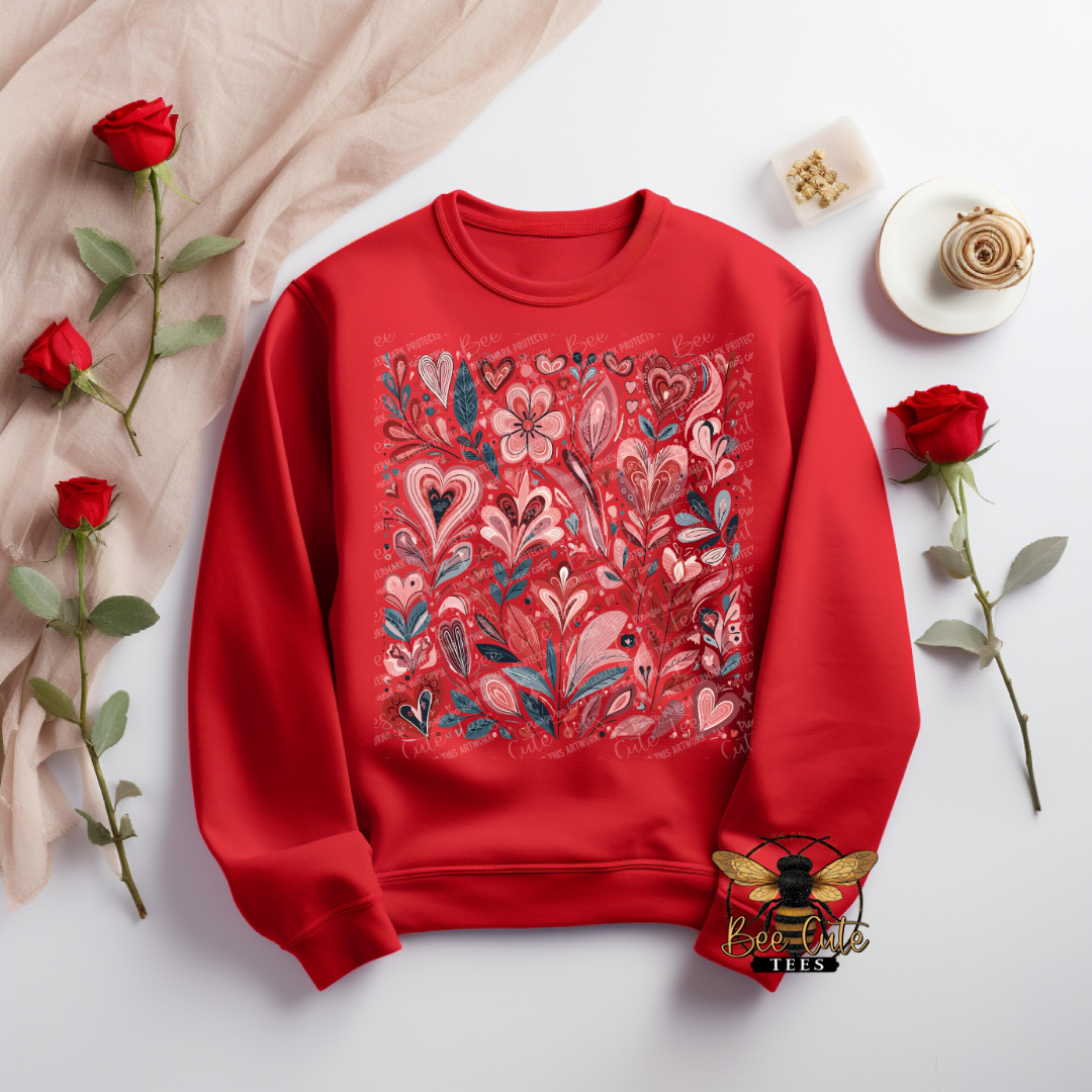 Red sweatshirt with floral and heart design on a light background with roses.
