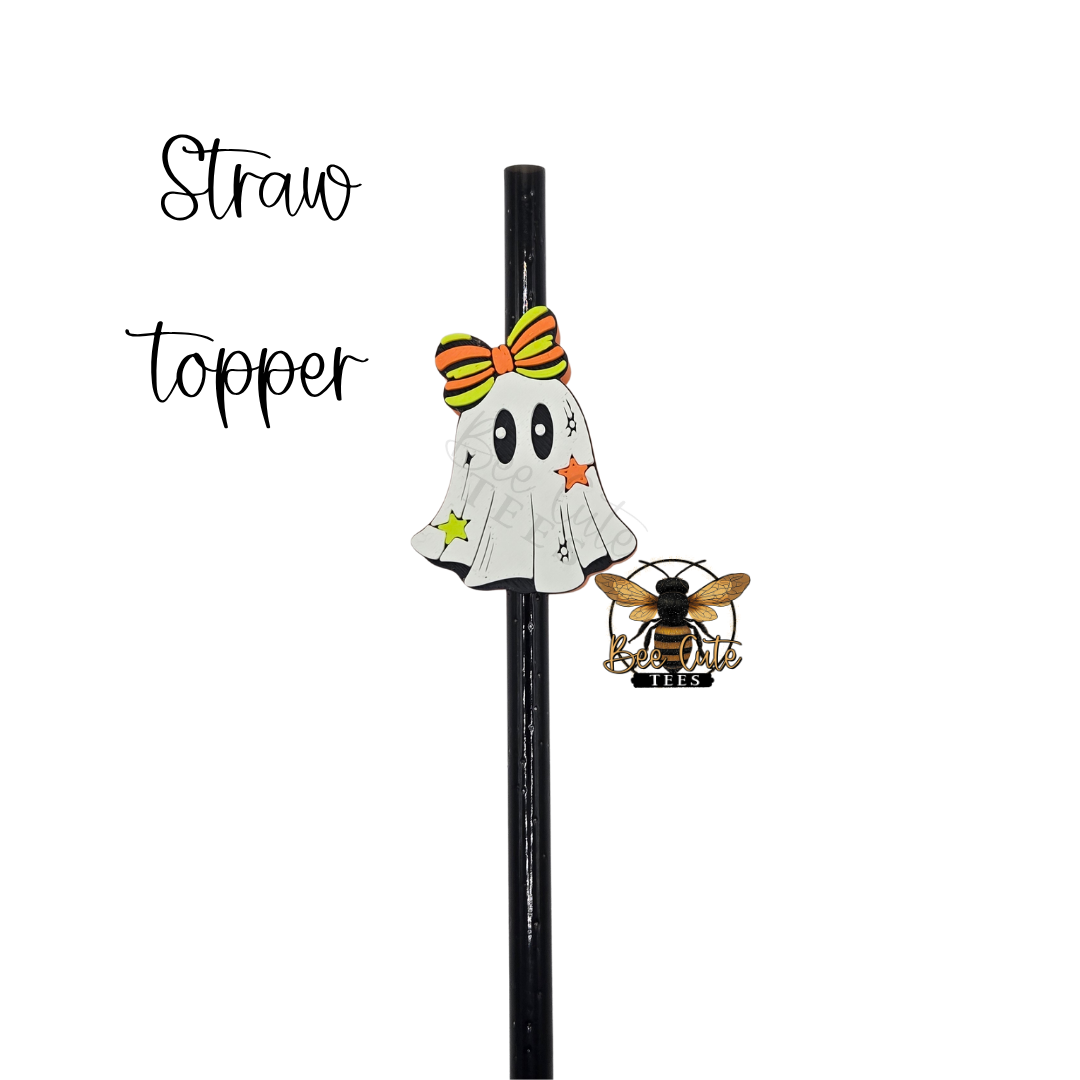 A black straw with Halloween-themed toppers, including a white ghost with a yellow and orange bow and a small bee topper, shown on a plain white background with the text 'Straw topper'.