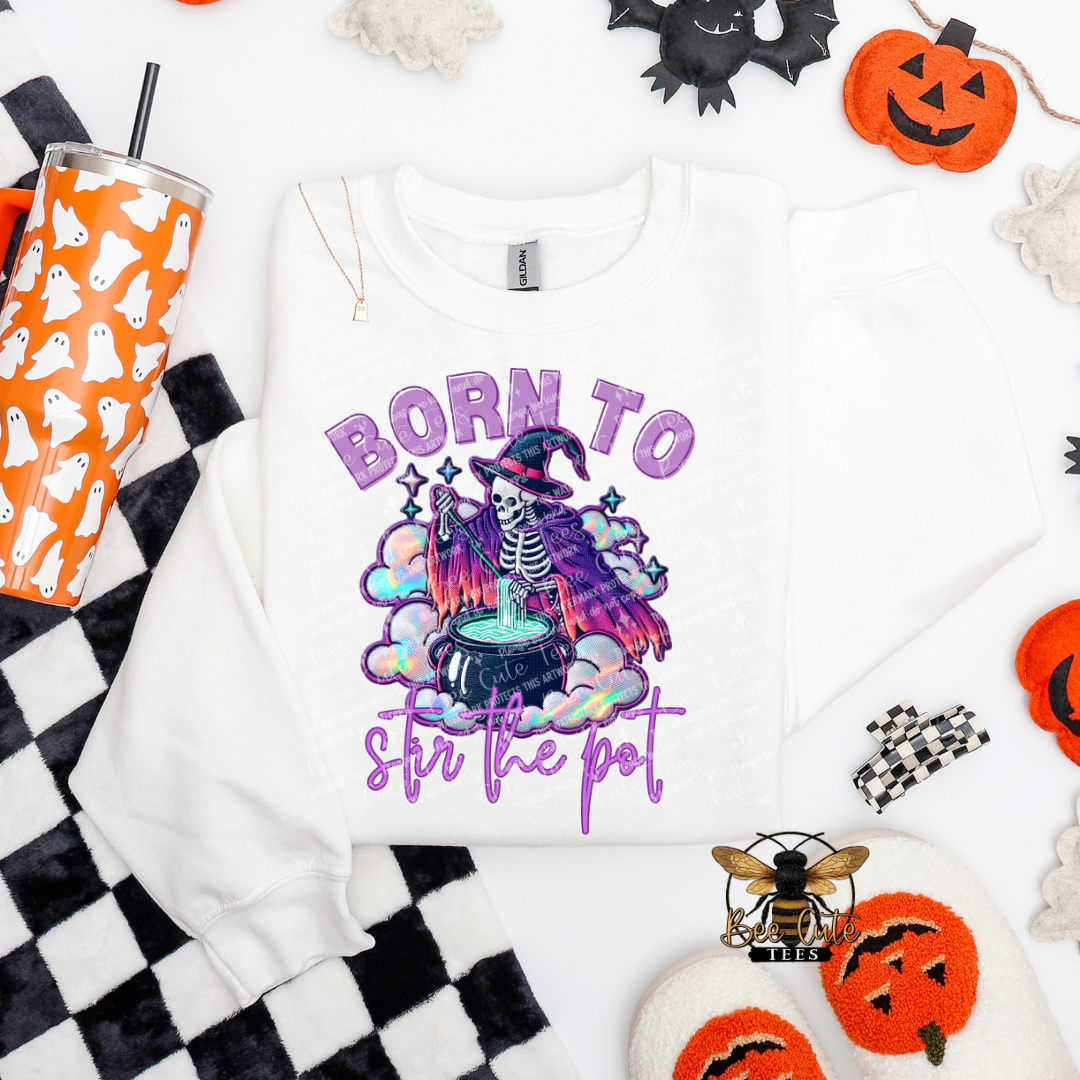 White sweatshirt with Halloween-themed design featuring a skeleton and text, surrounded by festive items.