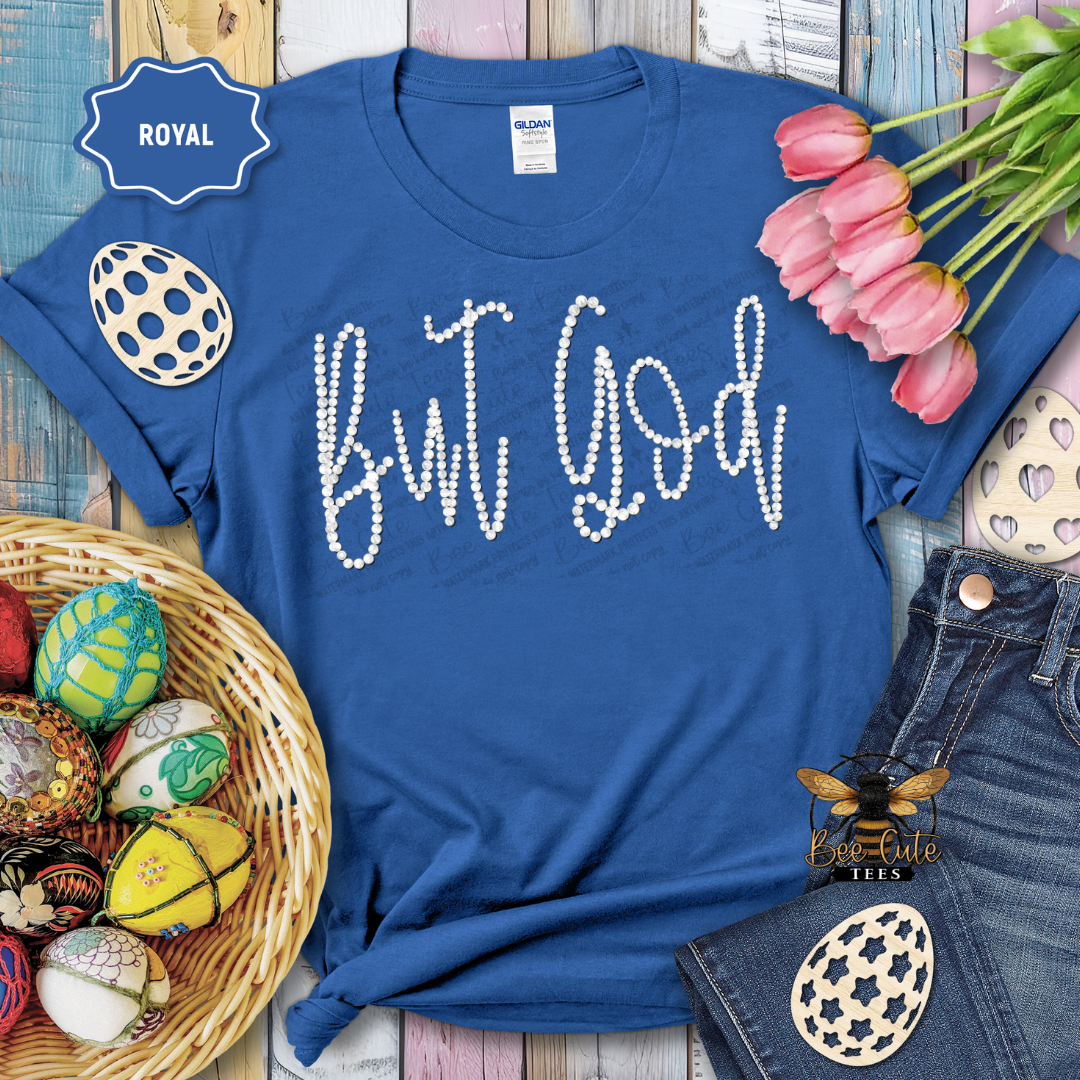 Blue t-shirt with 'But God' text, surrounded by Easter decorations on a wooden surface.