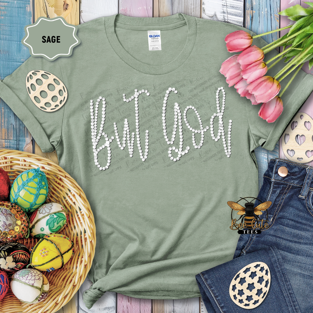 Green t-shirt with 'But God' text, surrounded by Easter decorations on a wooden surface.