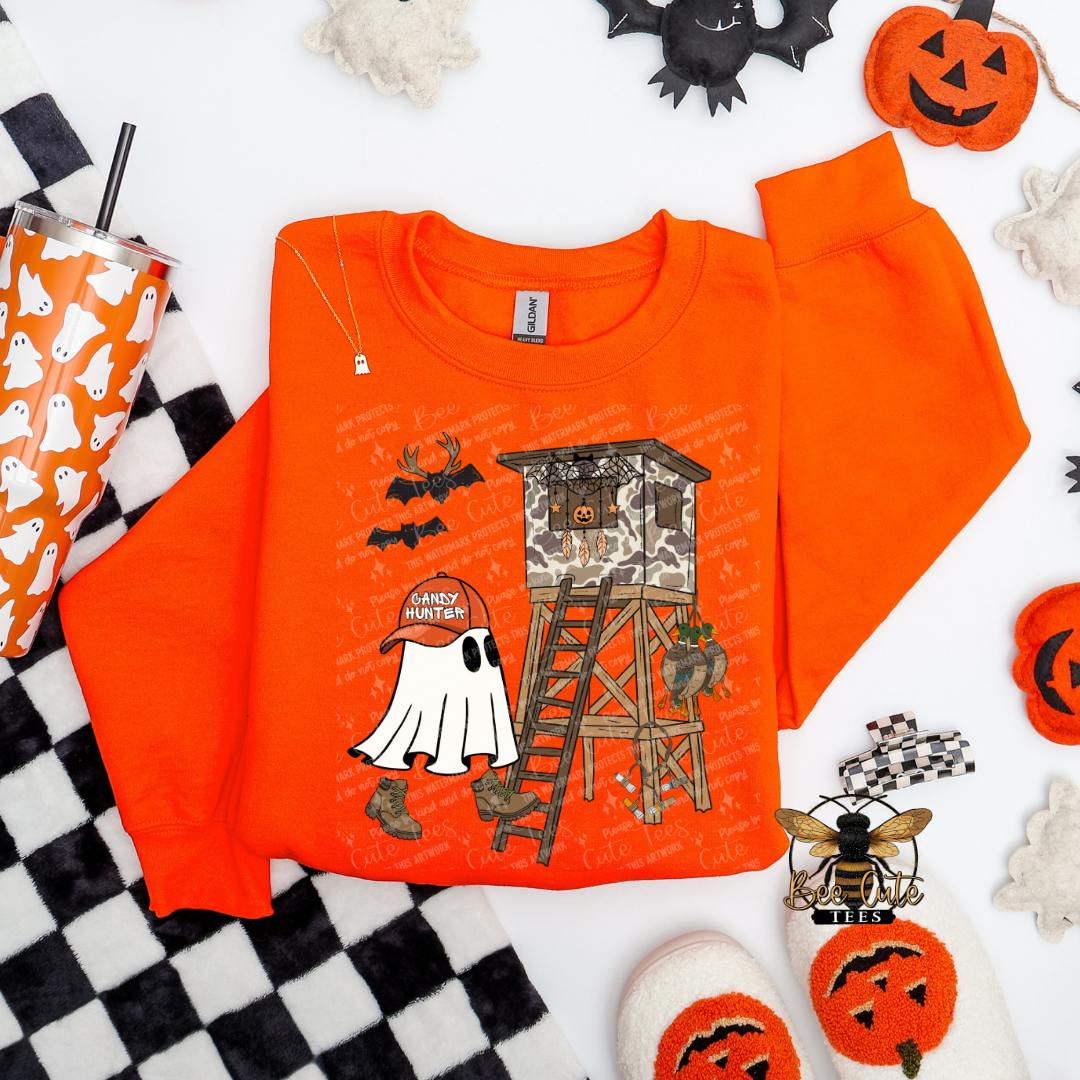 Orange sweatshirt with Halloween-themed design on a checkered background with Halloween decorations.