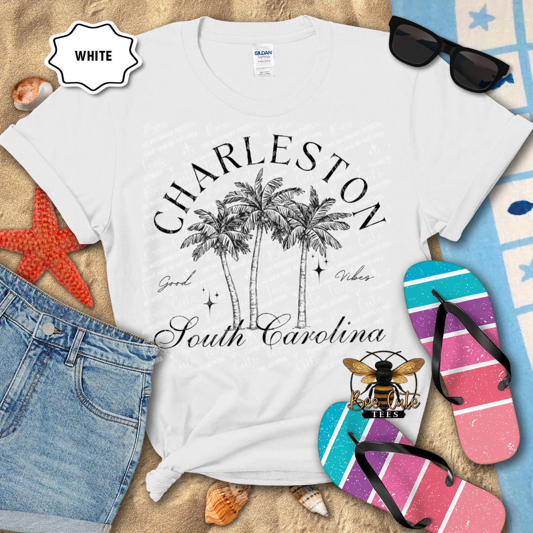 White t-shirt with 'Charleston South Carolina' design on a beach-themed background with flip-flops and sunglasses.