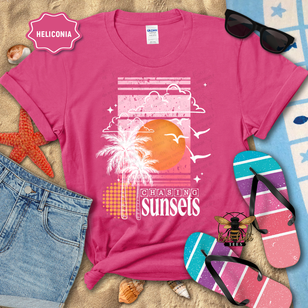 Pink t-shirt with 'Chasing Sunsets' design on a beach-themed background