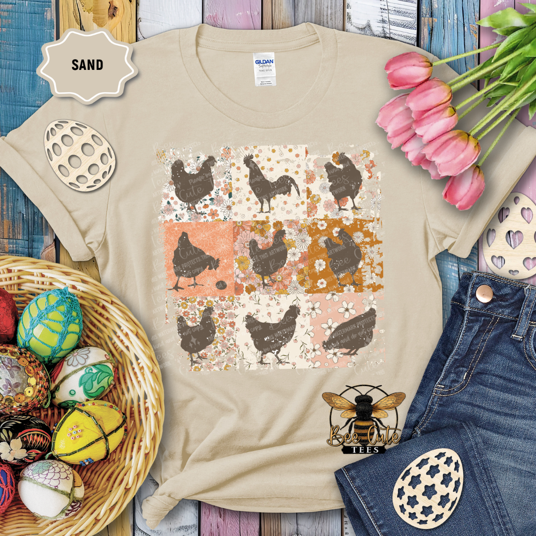 Beige t-shirt with chicken pattern, surrounded by Easter decorations on a wooden surface.