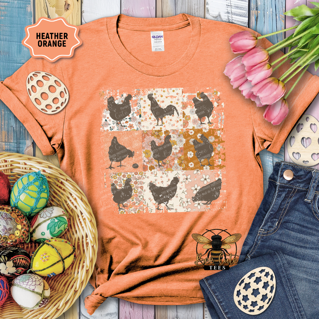 Orange t-shirt with chicken pattern, surrounded by tulips and decorative eggs on a wooden surface.