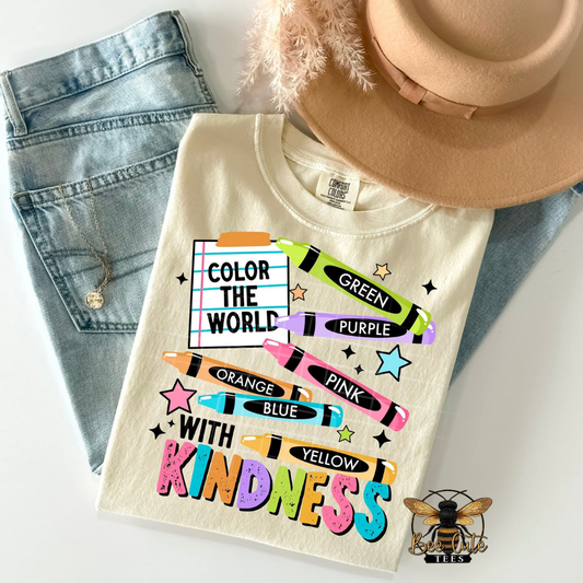 T-shirt with colorful text and crayon graphics, placed on jeans and a hat.