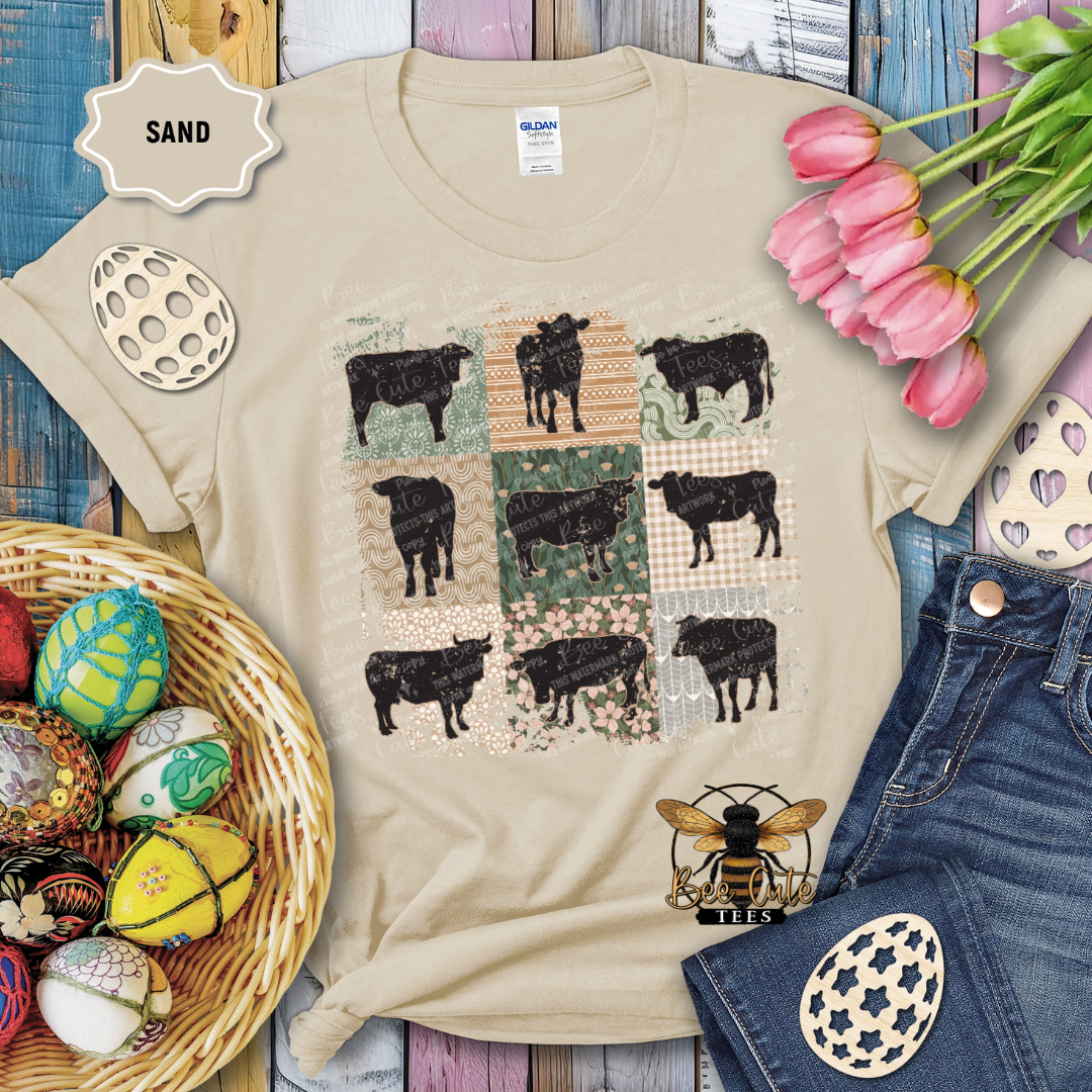 Beige t-shirt with cow pattern, surrounded by decorative items on a wooden surface.