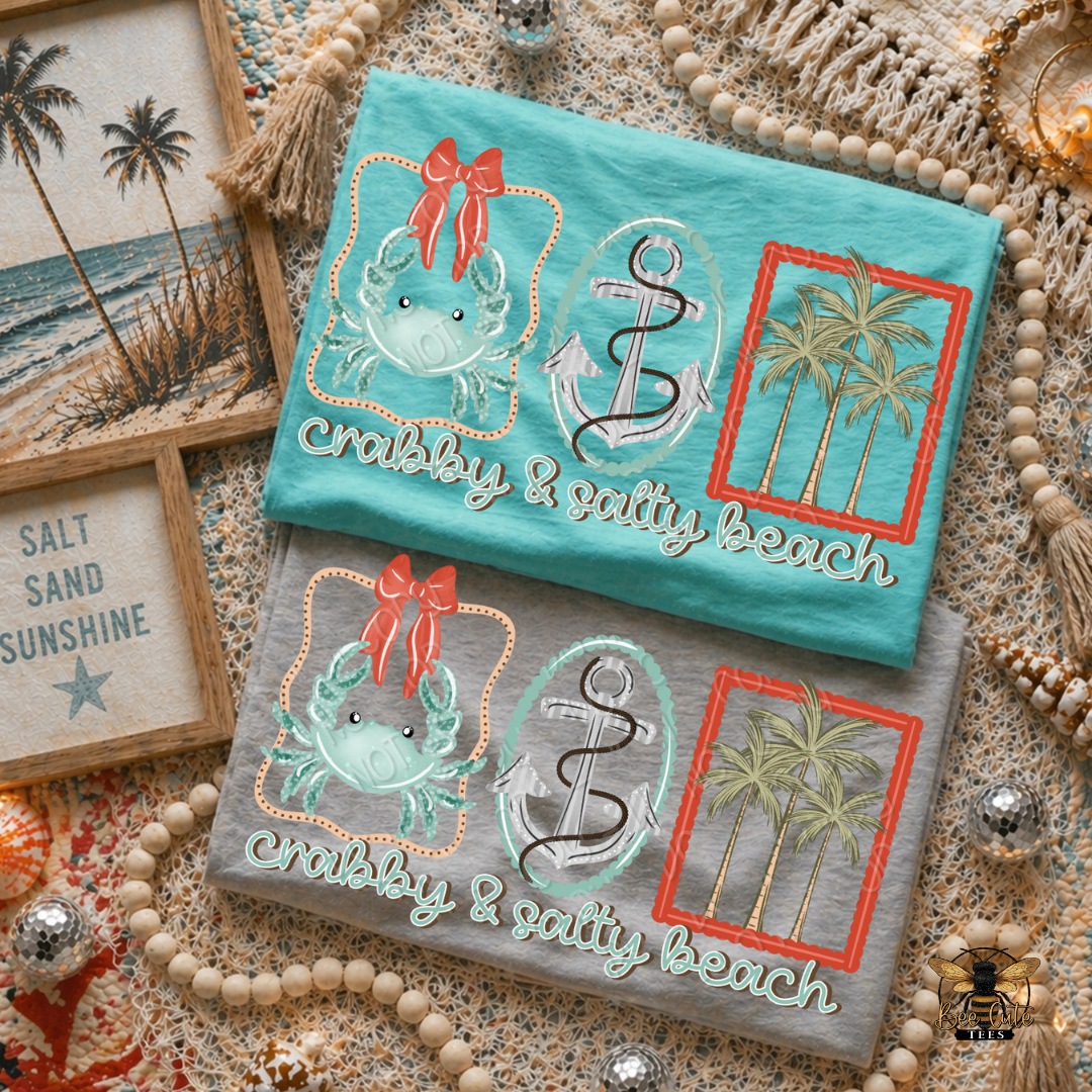 Two t-shirt with beach-themed designs on a textured surface.
