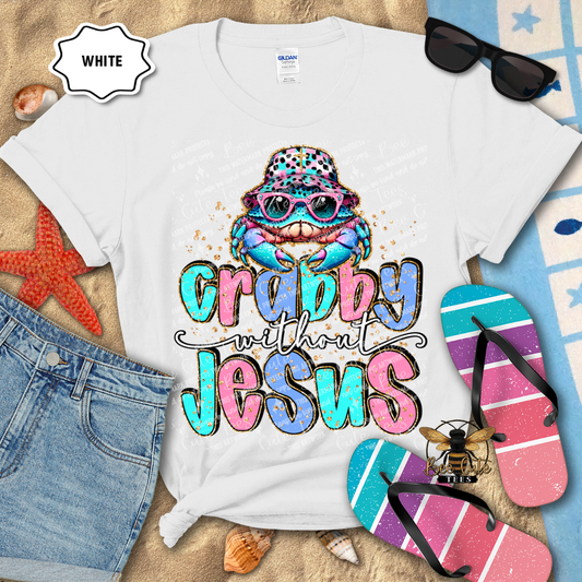 White t-shirt with colorful graphic and text 'Crabby without Jesus' on a beach-themed background.