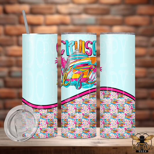 Colorful tumbler with 'Cruise Life' design on a wooden surface with brick wall background