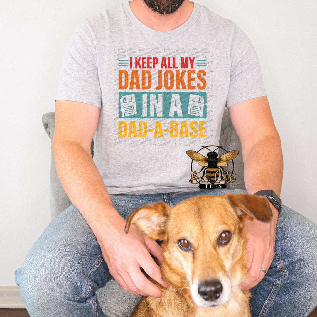Person wearing a t-shirt with a humorous design and a dog sitting next to them.