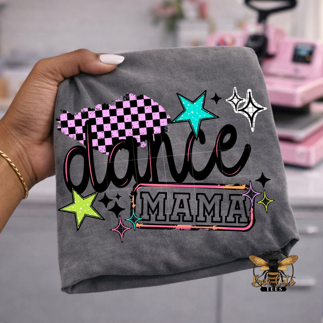 Gray t-shirt with 'dance mama' design held by a hand, with a blurred background.