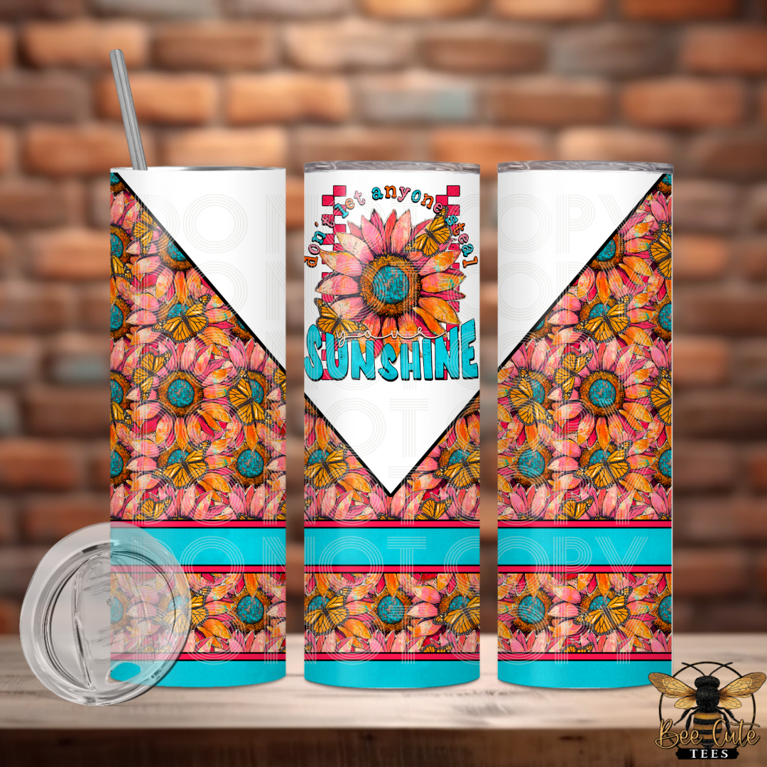 Colorful tumbler with floral design and 'Any Day is Sunshine' text against a brick wall background.