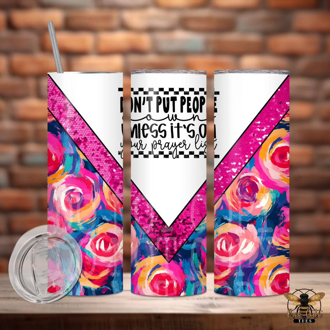 Colorful tumbler with floral design and motivational quote against a brick wall background