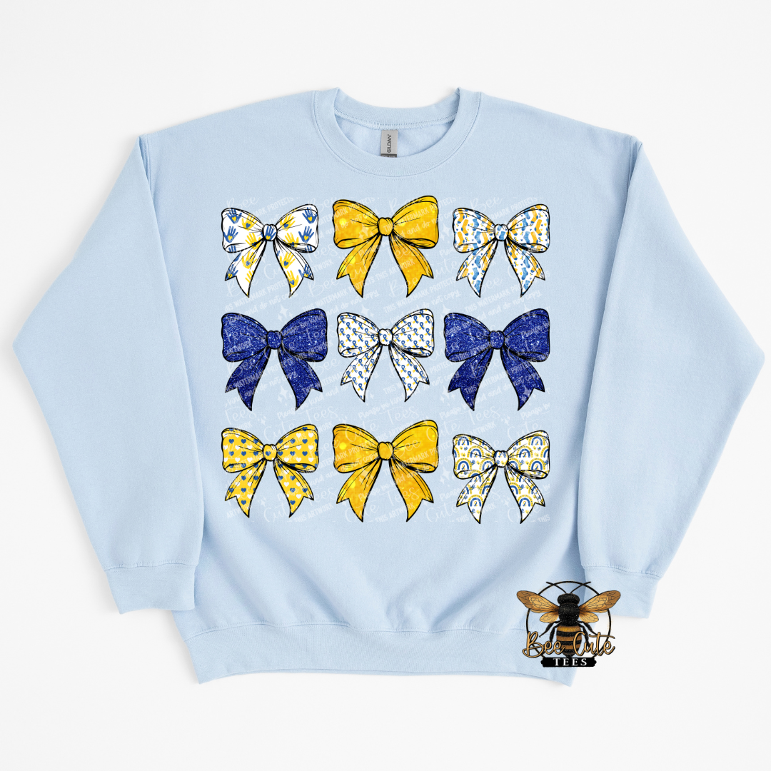 Light blue sweatshirt with colorful bow designs on a white background