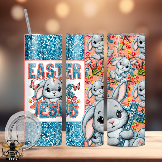 Tumbler with Easter design featuring bunnies and 'Easter Is For Jesus' text on a wooden surface.