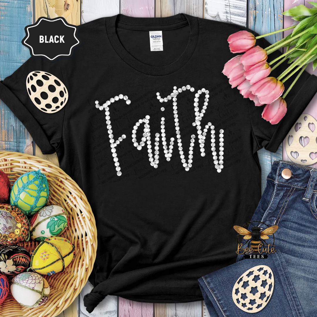 Black t-shirt with 'Faith' text, surrounded by Easter decorations on a wooden surface.