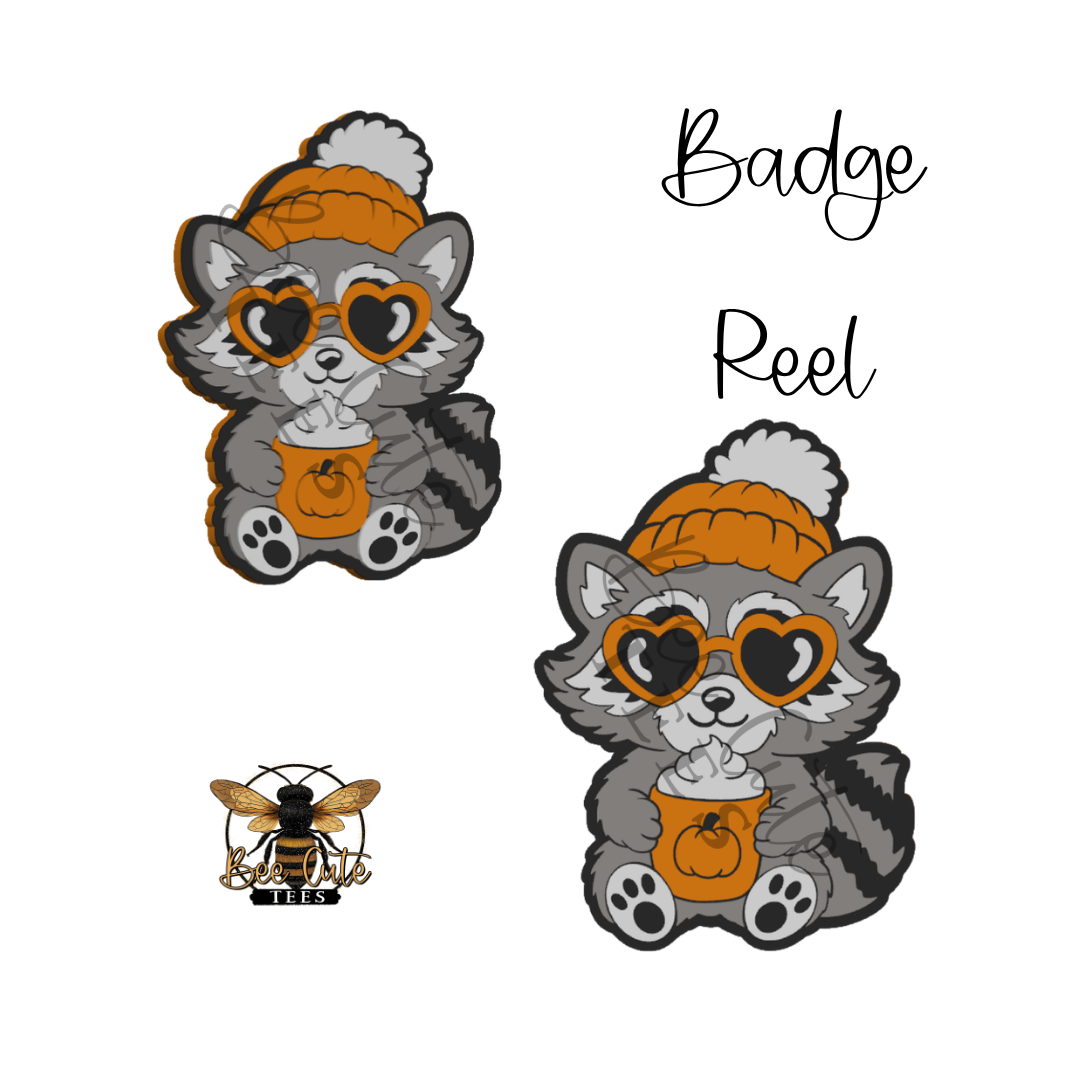 Two cartoon raccoon badges wearing orange knit hats and heart-shaped sunglasses, each holding an orange pumpkin cup, shown on a white background with the text 'Badge Reel' and a small bee logo reading 'BEE'.