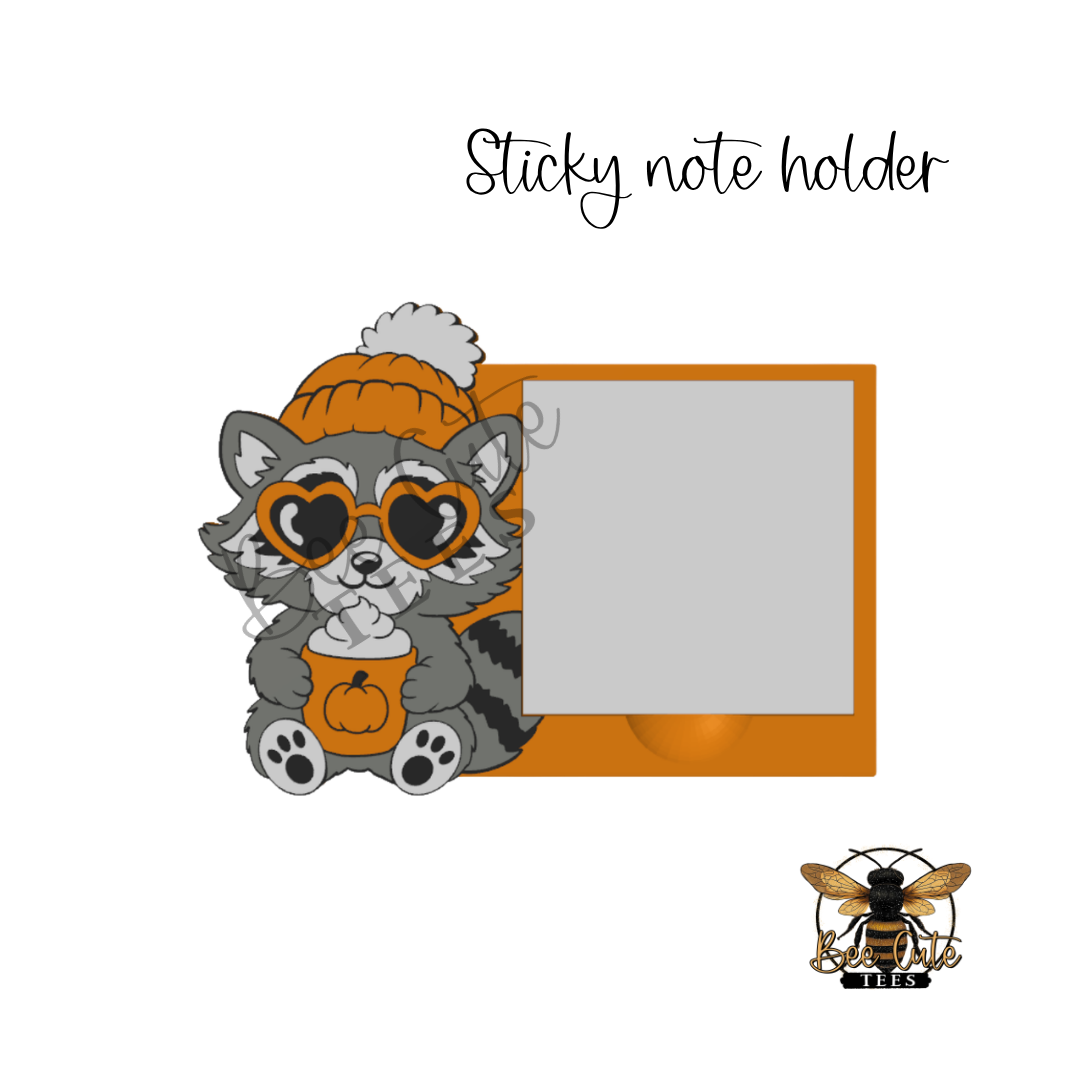 A cute cartoon raccoon wearing an orange beanie with a white pom-pom and orange heart-shaped sunglasses, holding a pumpkin cup, next to an orange sticky note holder template on a white background. The text 'Sticky note holder' appears at the top, and a small bee logo is at the bottom right.