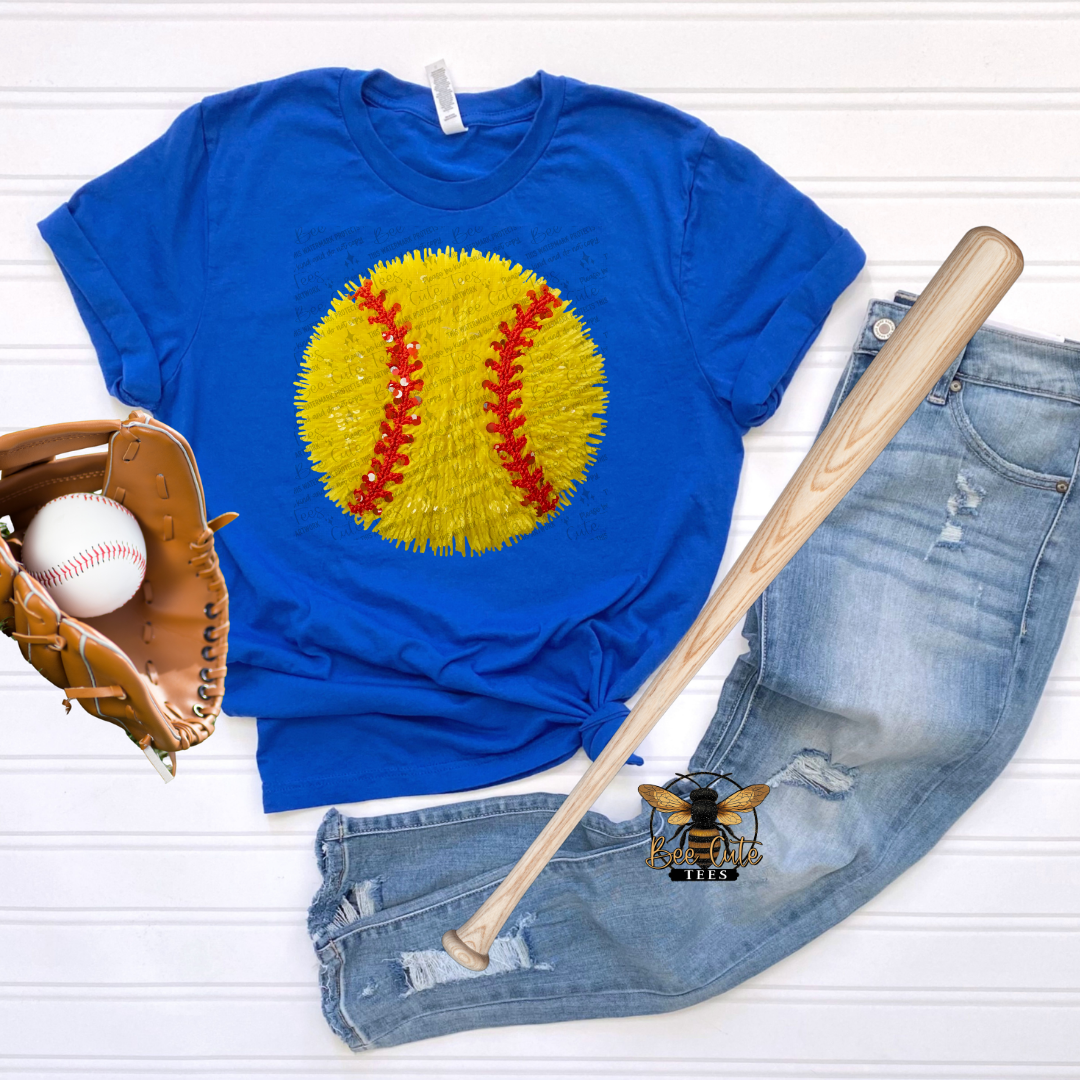 Blue t-shirt with yellow softball graphic, baseball, glove, and bat on a white background
