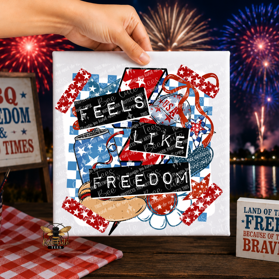 White T-shirt with 'Feels Like Freedom' text and patriotic design held by a hand with fireworks in the background.
